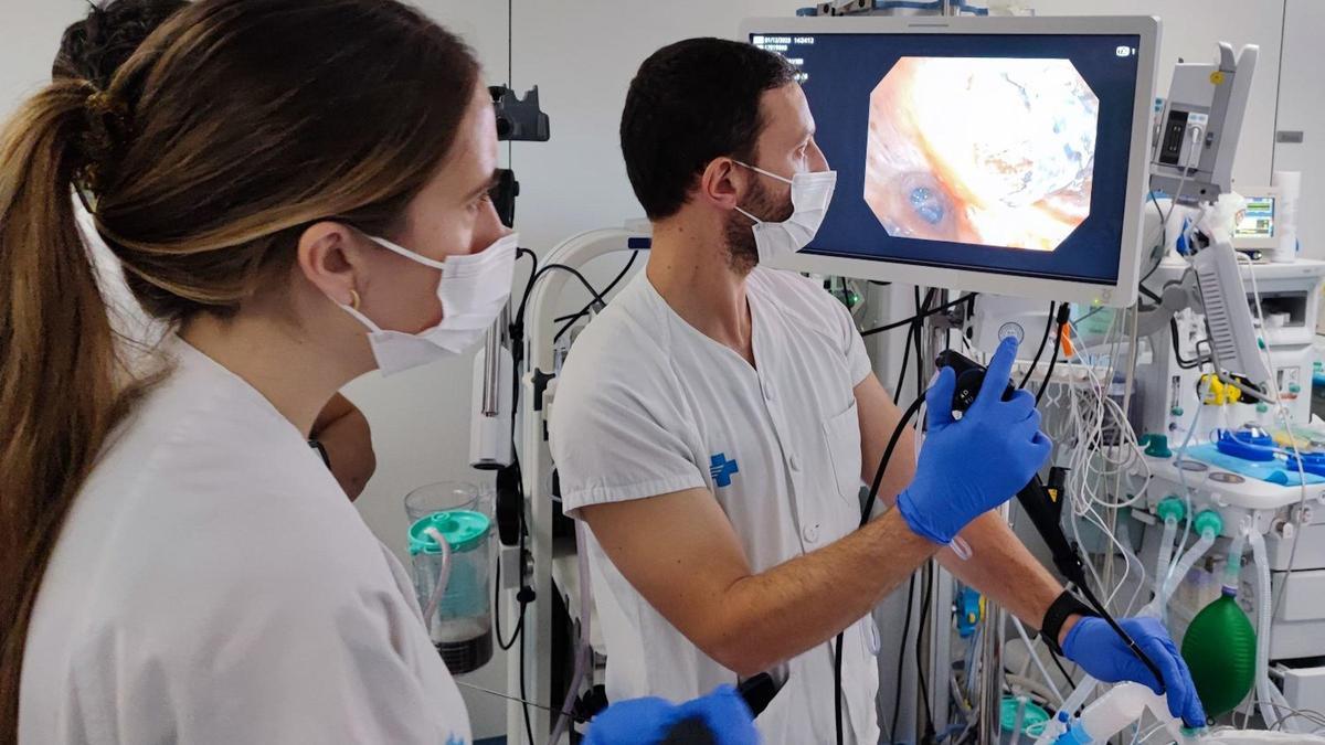 Dos professionals de l'hospital Trueta de Girona comproven en una pantalla l'estat dels pulmons d'un pacient per col·locar-hi una vàlvula