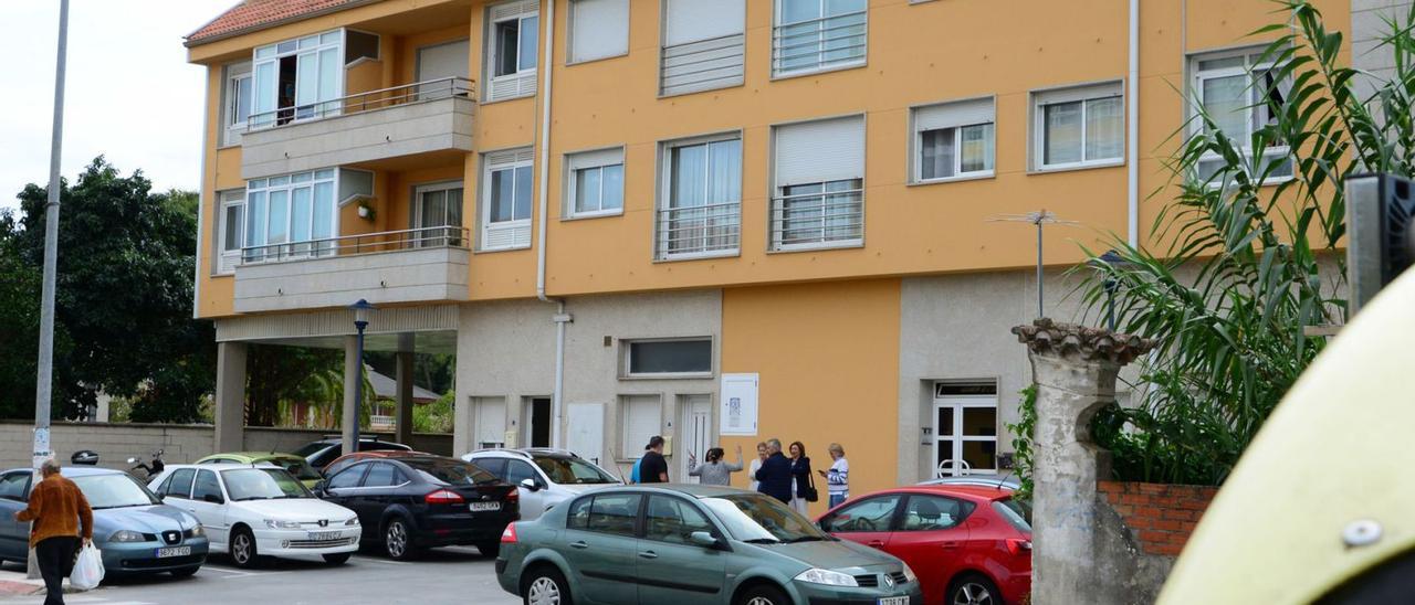 Vecinos afectados en la fachada del edificio de la avenida de Ourense donde se encuentran los pisos okupados.