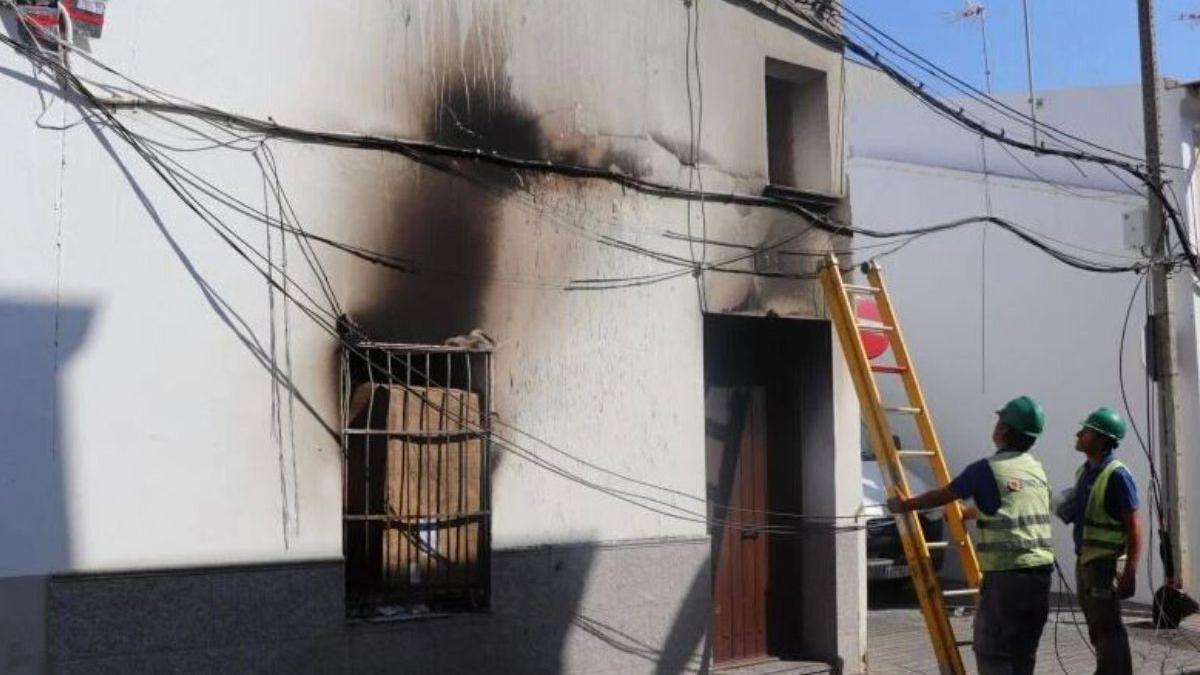 Dos operarios inspeccionan el estado de la instalación eléctrica tras el incendio.