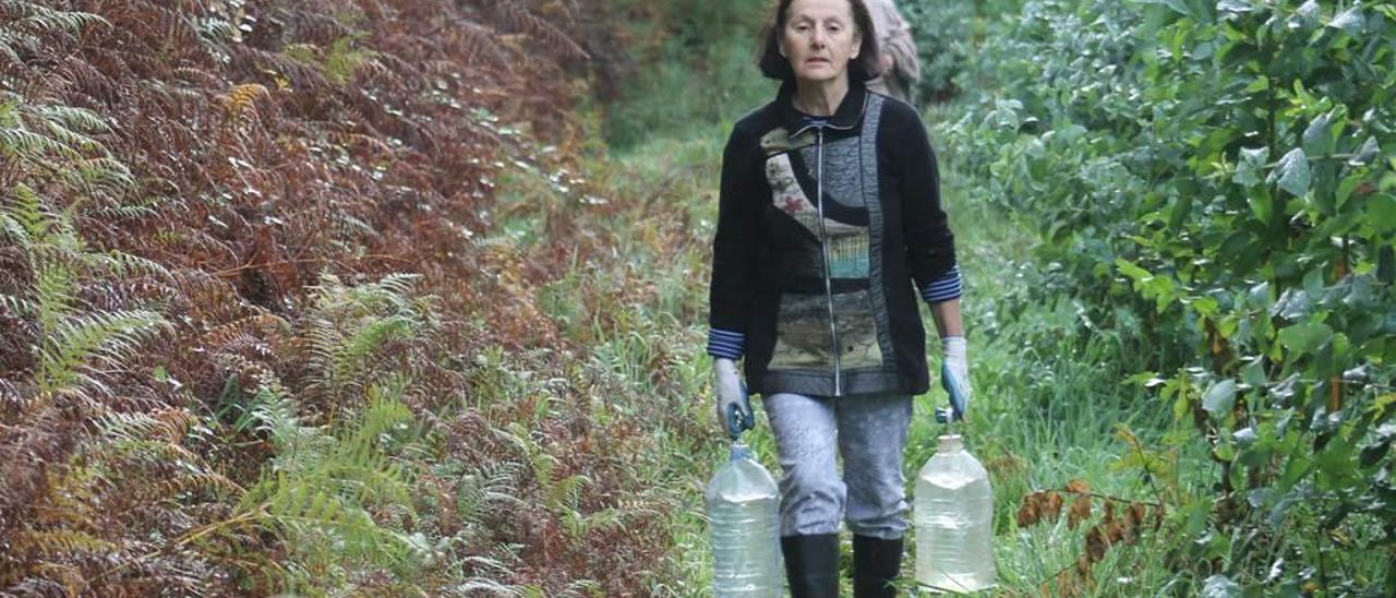 Carmen Arrojo, con los diez litros de agua que lleva a su finca.