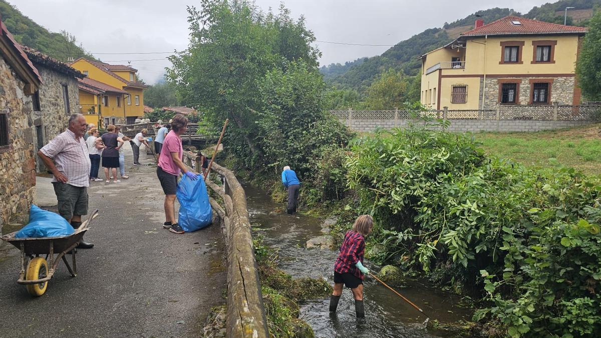 Vecinos de La Pola Vieya limpiando el río Rosaliego.