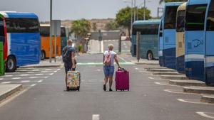 Una pareja de turistas extranjeros arrastra sus maletas a la salida del aeropuerto Tenerife Sur.