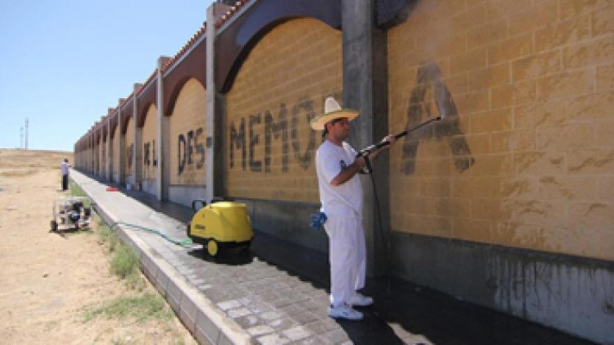 Limpian la pintada del muro del cementerio