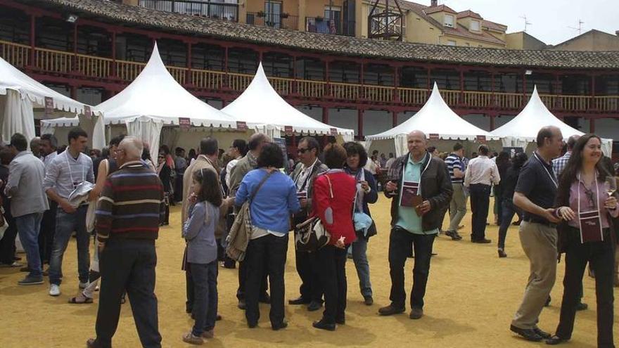 Asistentes a una de las ferias del vino de Toro prueban los caldos en la plaza de toros.