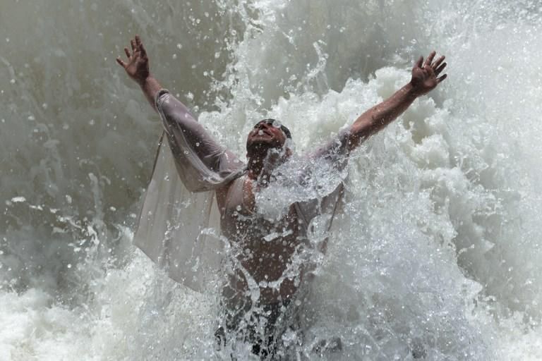 Un afgano se refresca en un caluroso día de verano / AFP PHOTO / NOORULLAH SHIRZADA