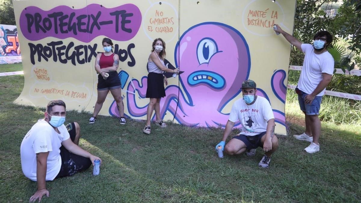 La alcaldesa de Gavà en el Parc del Mil·leni al lado de la pintada del mural con artistas locales.