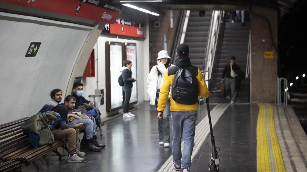 Un usuario de patinete eléctrico en la estación de metro de plaza Espanya en Barcelona