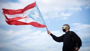 Bad Bunny ondea la bandera de Puerto Rico durante las protestas contra el gobernador Ricardo Roselló, en julio del 2019