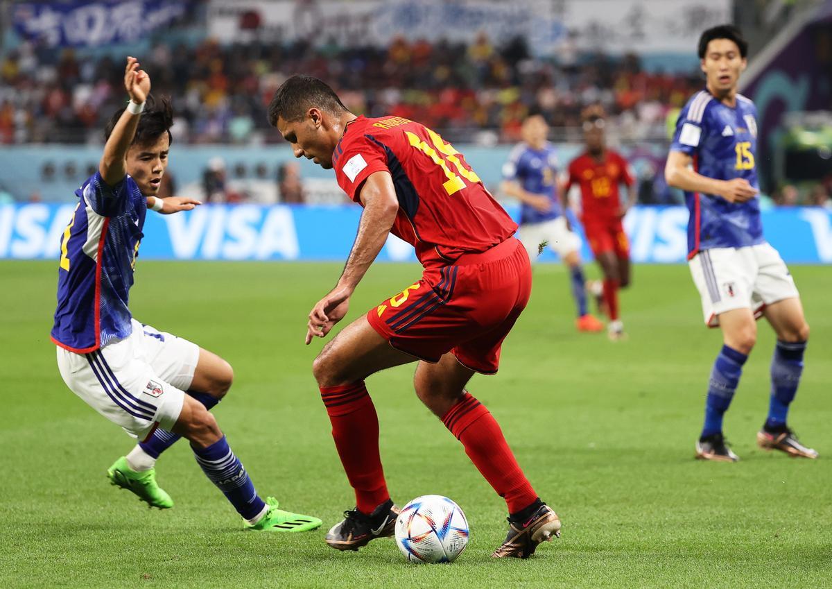 Doha (Qatar), 01/12/2022.- Takefusa Kubo (L) of Japan in action against Rodrigo (C) of Spain during the FIFA World Cup 2022 group E soccer match between Japan and Spain at Khalifa International Stadium in Doha, Qatar, 01 December 2022. (Mundial de Fútbol, Japón, España, Estados Unidos, Catar) EFE/EPA/Ali Haider