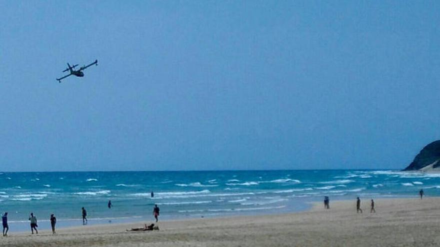 Imagen reciente de un avión sobrevolando las playas de Morro Jable con turistas sobre la arena.