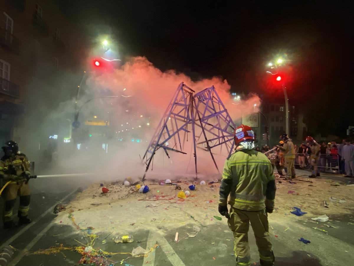 Un bombero mira lo que queda en pie del Catafalco tras apagar las llamas sus compañeros.