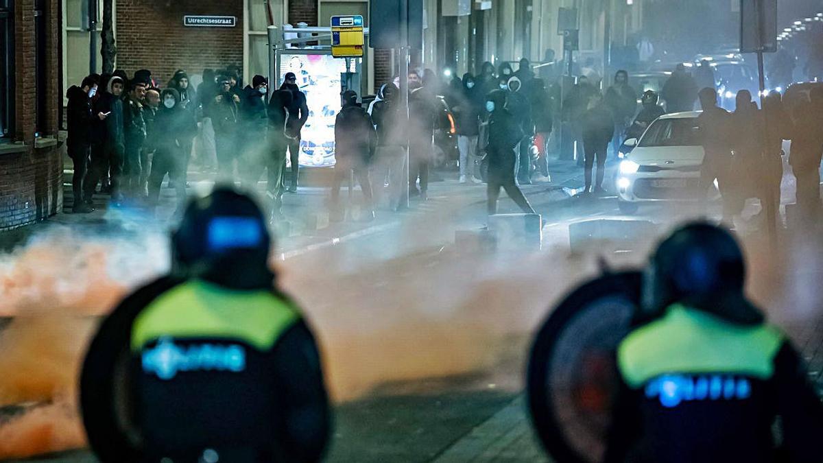 Policías intentan frenar el avance de los jóvenes protestantes.   | // EFE