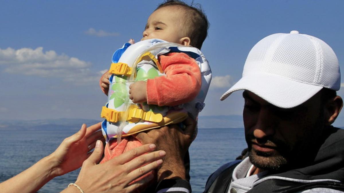 Un bebé llega a la isla griega de Mytilini tras salir de Turquía, este domingo.