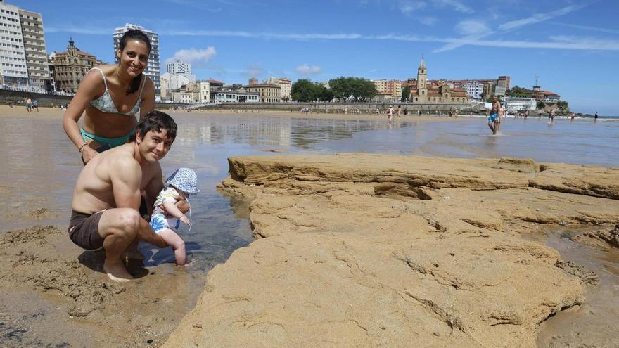 Los movimientos de arena de la playa de San Lorenzo dejan al descubierto una roca de grandes dimensiones en la Escaleron: "Llevo viniendo 70 años y jamás la vi"
