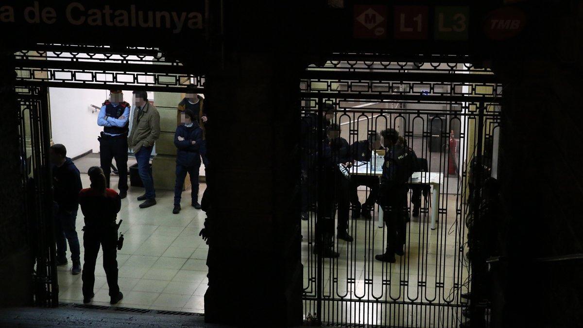 Varios policías en el subterráneo bajo las fuentes de la plaza de Catalunya, donde comprueban identidades de sospechosos.