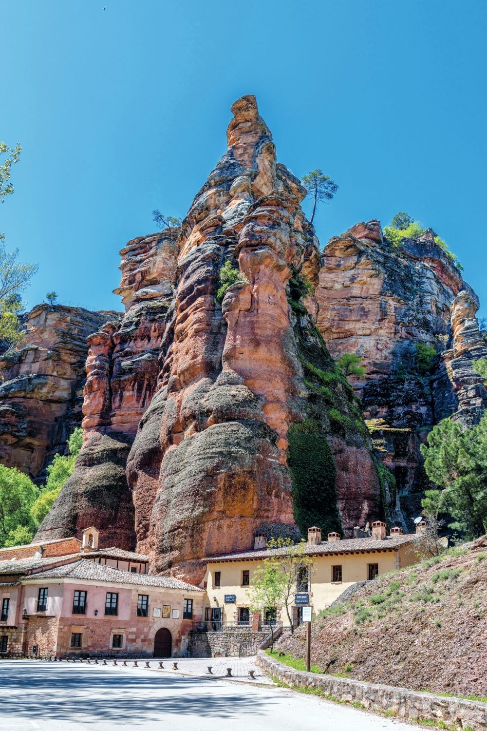 Ermita de la Virgen de la Hoz, enclavada bajo las imponentes formaciones rocosas del Barranco de la Hoz, en el Parque Natural del Alto Tajo. Este santuario del siglo XIII, construido tras la reconquista de Molina por Alfonso I "El Batallador", combina arquitectura románica y gótica, y se integra armónicamente en el paisaje de areniscas rojizas moldeadas por la erosión a lo largo de millones de años.