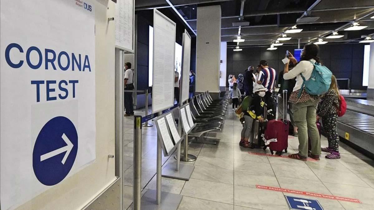 Alemania recomienda no viajar a Catalunya, Aragón y Navarra. En la foto, pasajeros recién llegados a Alemania esperan para realizarse un test de coronavirus en el aeropuerto de Dusseldorf, el lunes 27 de julio.