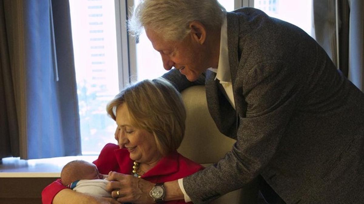 Hillary y Bill Clinton, con su nieto.