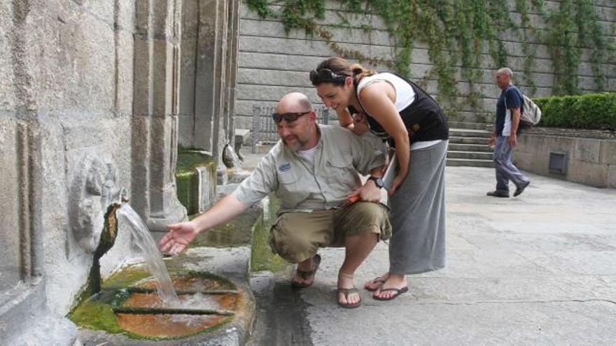 Una pareja de turistas, ayer, en As Burgas, uno de los puntos más visitados de la ciudad.  // Iñaki Osorio