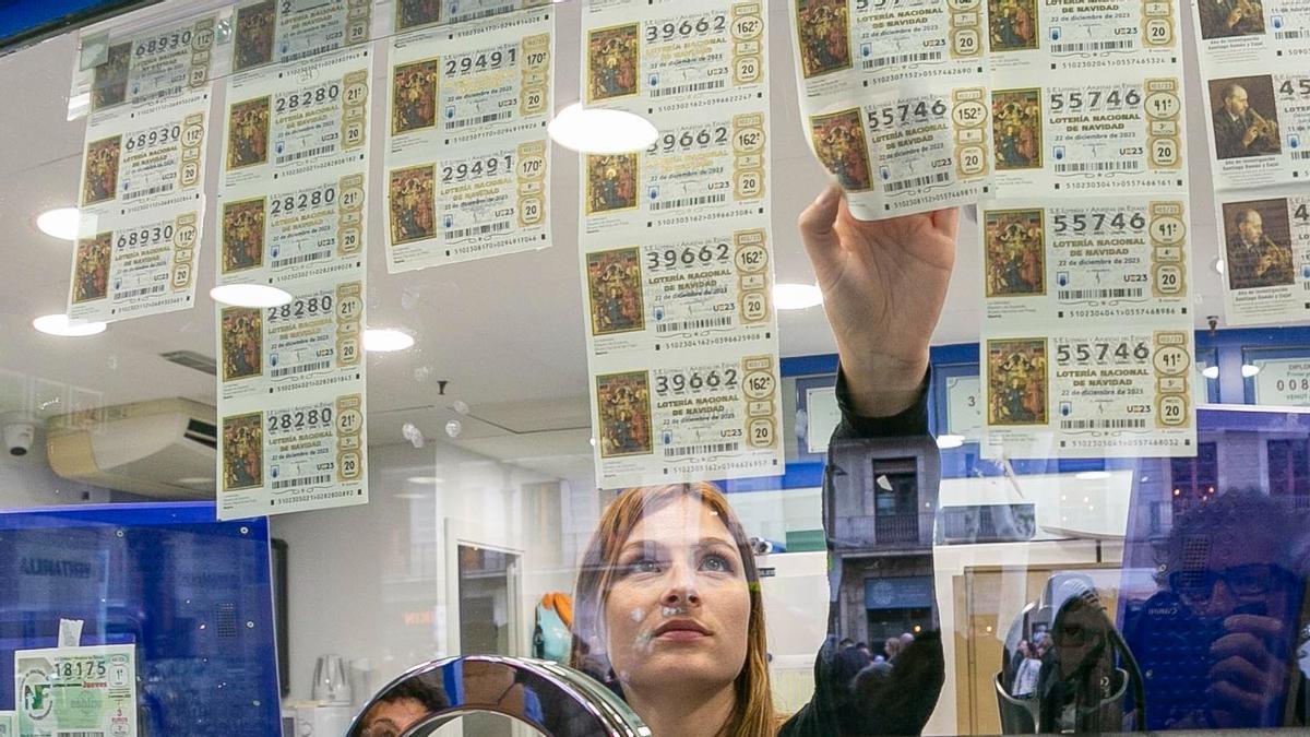 Una lotera coge un décimo de la Lotería de Navidad en Barcelona.