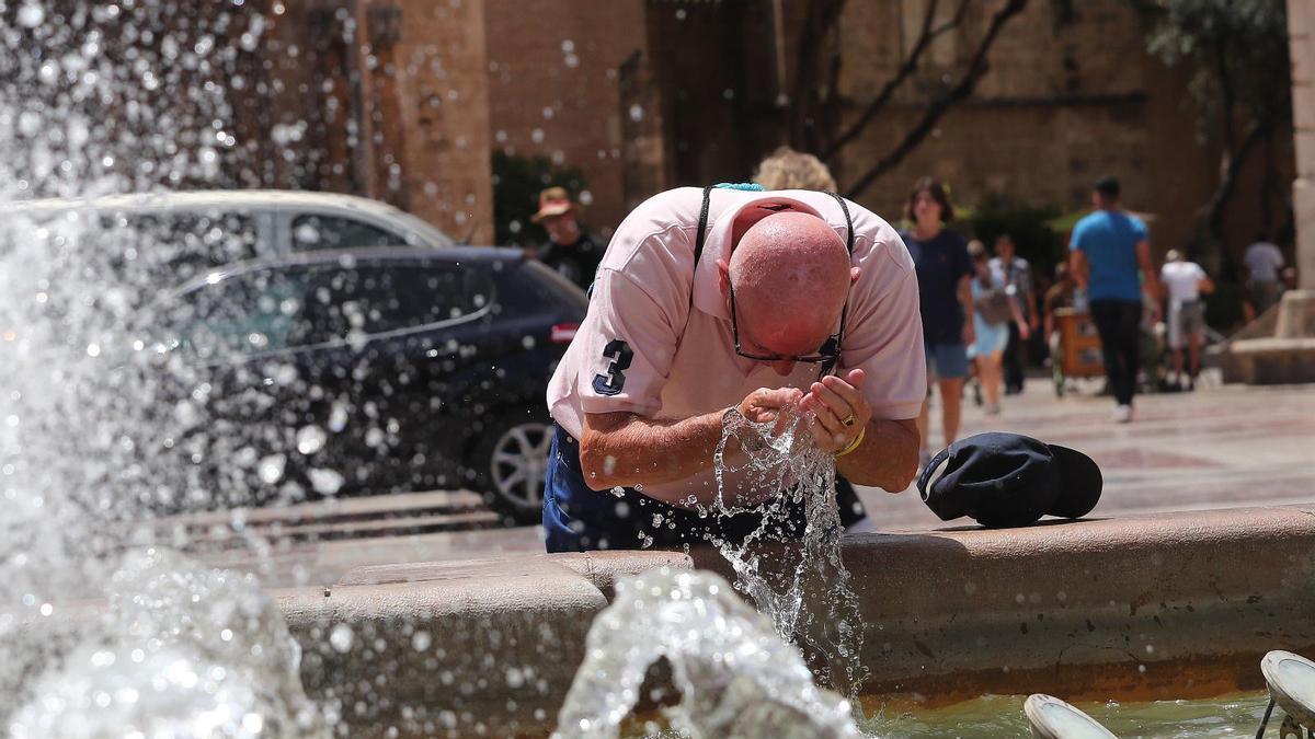 Hombre refrescándose en una fuente
