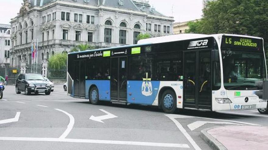 El autobús de San Claudio entra en la calle Uría, dejando el edificio de la Junta General tras él.