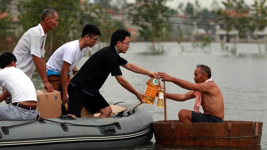 Un grupo de voluntarios entrega comida a un hombre en la provincia de Hebei.