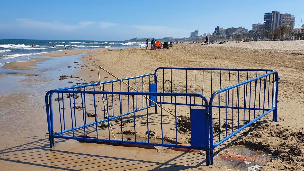 Unas vallas &quot;protegen&quot; una tubería desenterrada por el mar en la playa de San Juan en una imagen de este martes