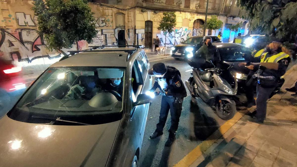 Agentes de la Policía Nacional y Local realizan un control policial en Orriols. | FERNANDO BUSTAMANTE