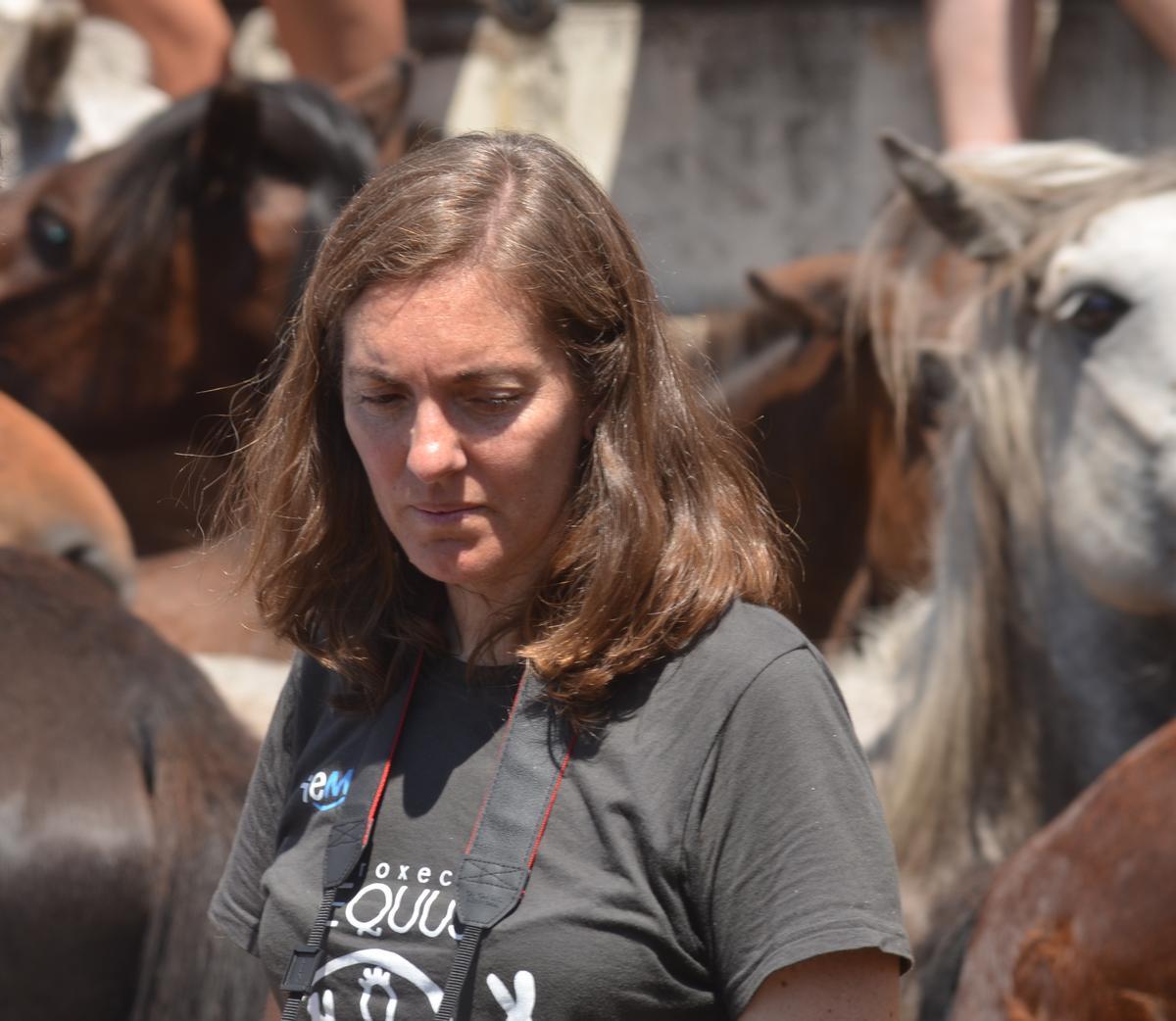 La investigadora viguesa Laura Lagos, rodeada de caballos en un curro.