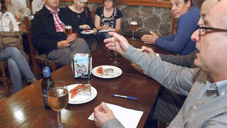 Profesores de la Universidad de Elche impartiendo una conferencia en un bar de la localidad.