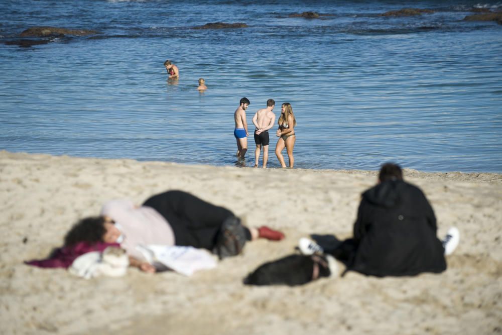 Bañistas en otoño en la playa de Riazor