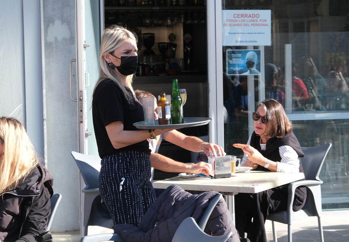 Una camarera atiende una mesa en una cafetería de Elche