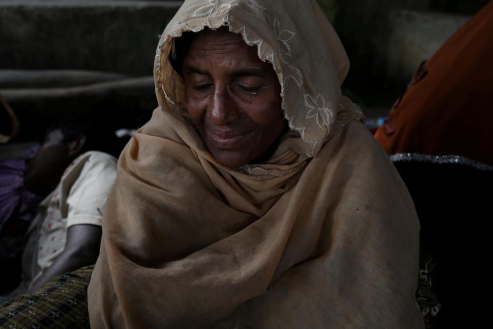 Rohingya refugee Almor Yhan cries while she ...