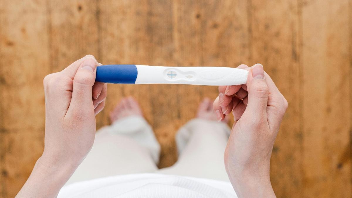 Una mujer consulta el resultado de un test de embarazo