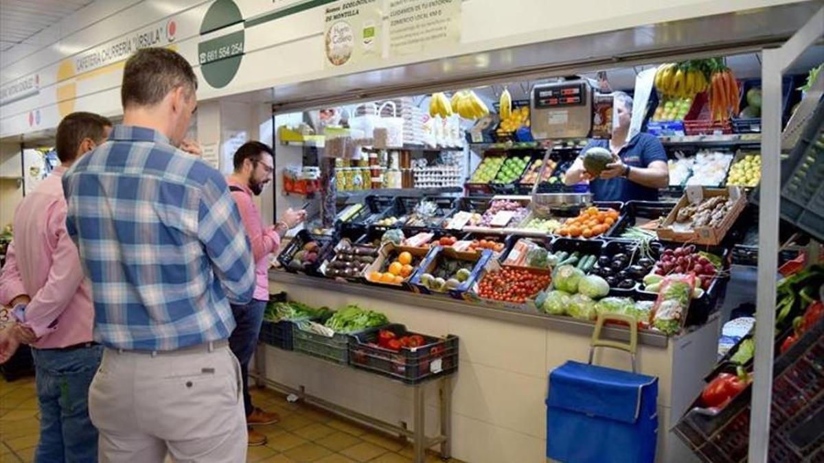 Compradores en una frutería de un mercado de abastos de Córdoba.