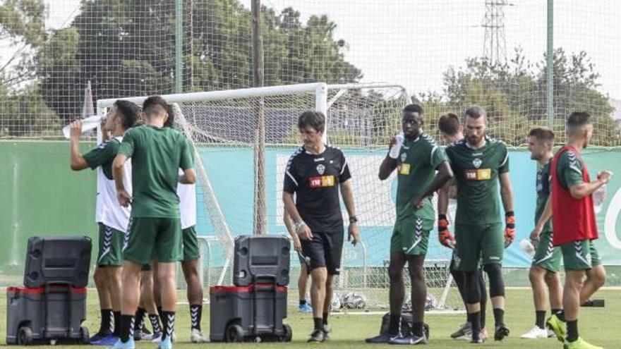 Los jugadores del Elche se refrescan durante un entrenamiento, con Pacheta en el centro.