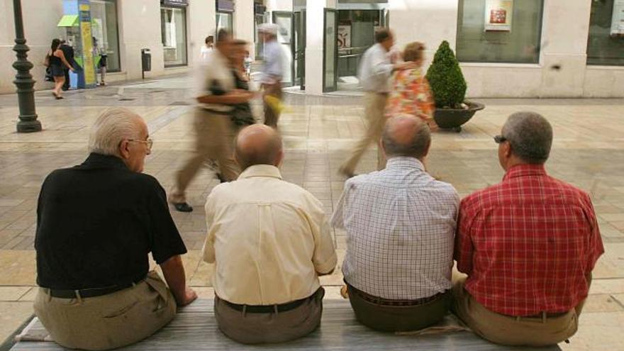 Jubilados en un banco de la calle Larios.