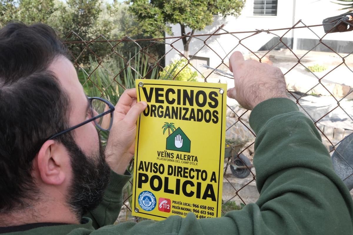 Un vecino coloca un cartel disuasorio de la plataforma del Camp d'Elx