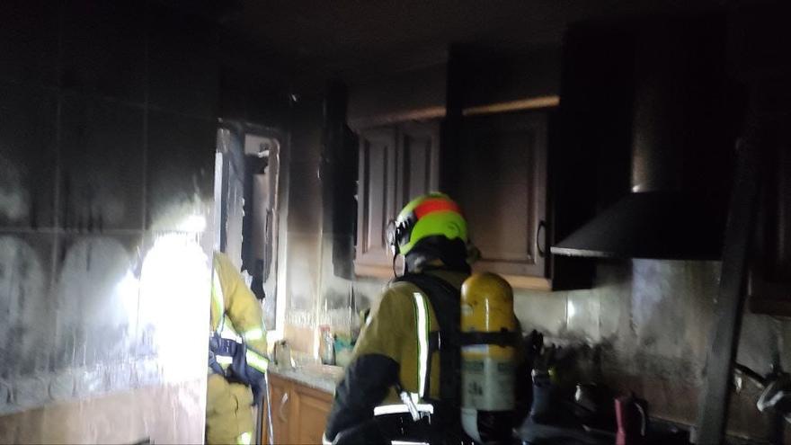 Los bomberos en la cocina terminando de apagar el incendio.