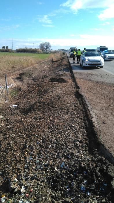 La Policia Local de Dolores y Almoradí desvía el tráfico mientras se retira de la calzada cientos de kilos de vídrio