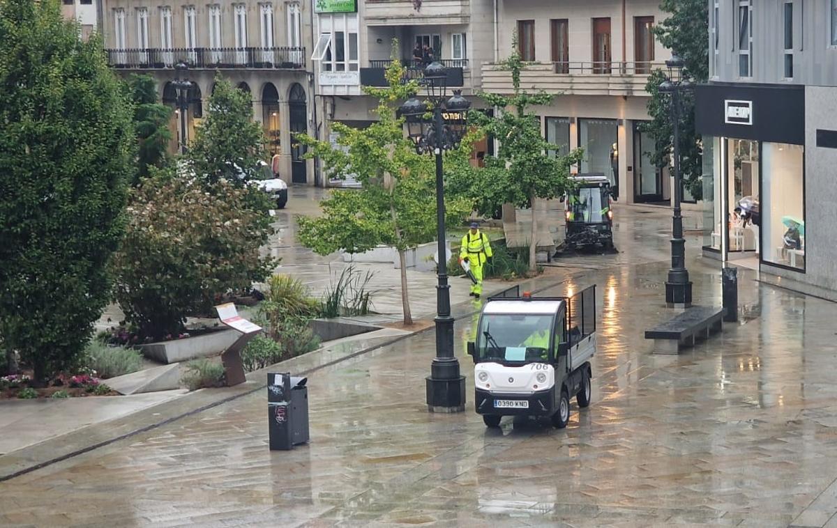 Un operario y dos de las máquinas de Urbaser limpiando en la plaza de Galicia.