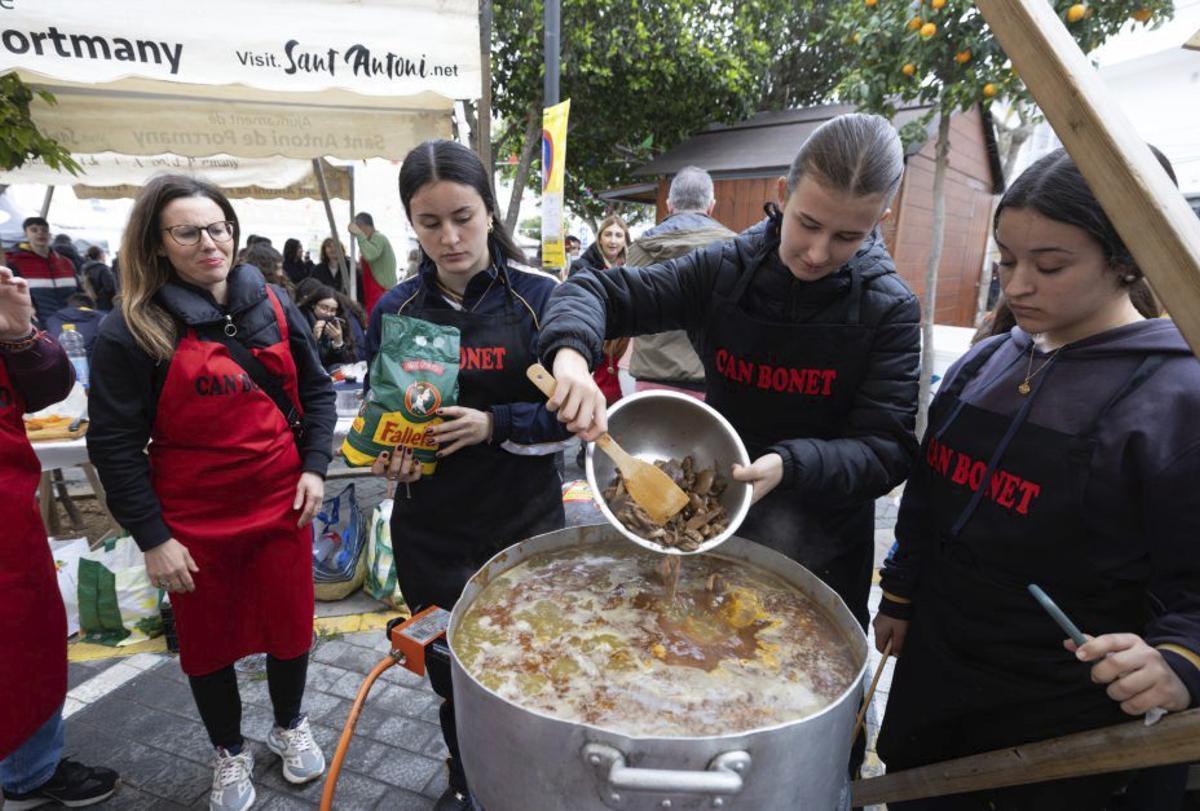 Unas jóvenes vierten las setas en el arroz de matanzas, en uno de los concursos. | VICENT MARÍ