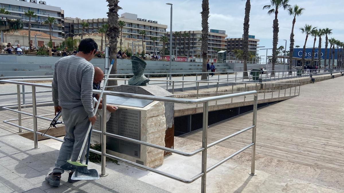 Dos operarios colocan las nuevas placas en el monumento del Stanbrook del puerto de Alicante.