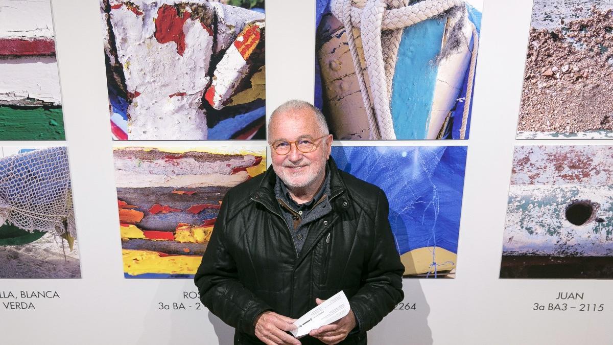 Albert Isern, junto a sus fotografías de las desaparecidas barcas de Badalona, en la exposición 'Amoramar'