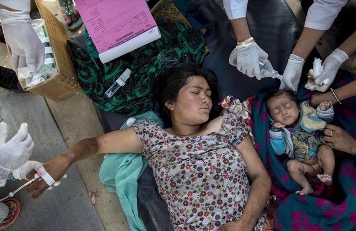 Una mujer herida y su hija reciben tratamiento médico después de llegar al hospital de Dhading , a raíz del terremoto del sábado , en Dhading Besi.