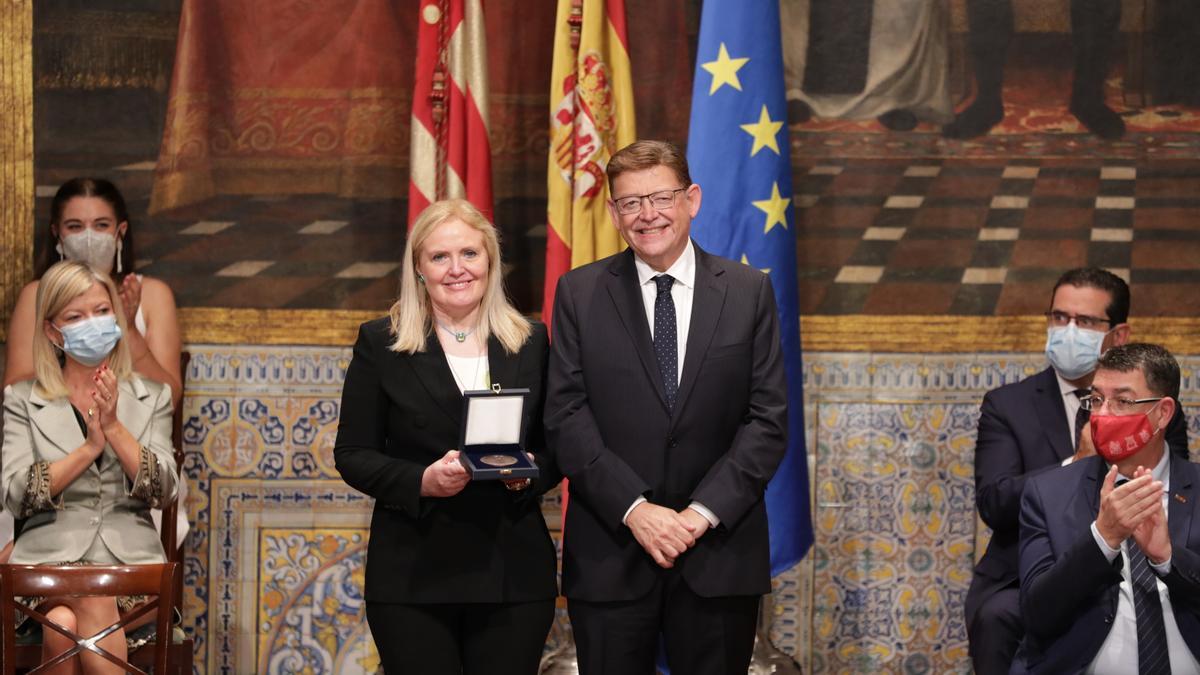 Dolores Corella recibiendo la distinción de manos el president, Ximo Puig.