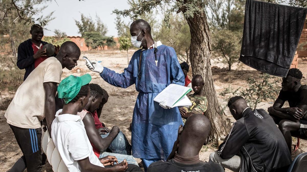 Un sanitario toma la temperaturas a jóvenes en Dakar, Senegal.