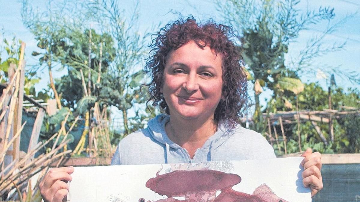 La artista Lola Escámez posando con una de sus obras de 'wine art'.
