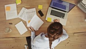 Businesswoman working at her office desk with documents and laptop